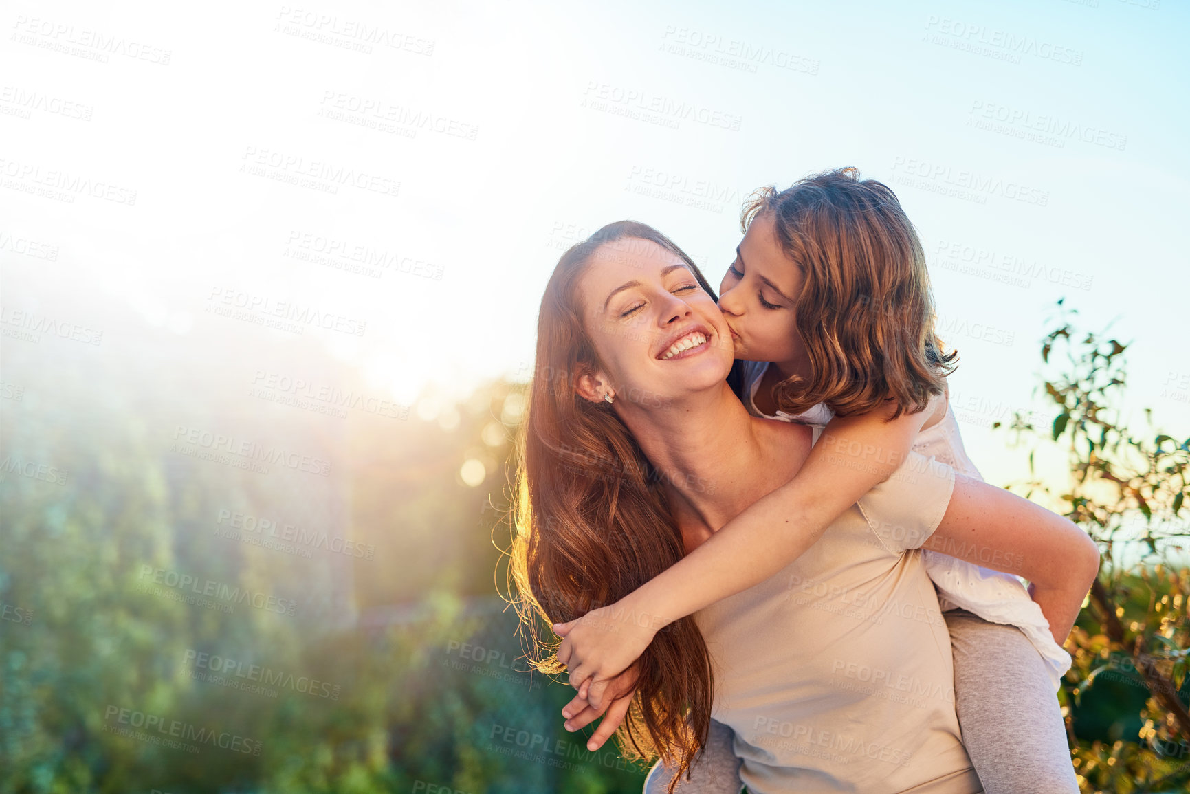 Buy stock photo Cropped shot of a young girl giving her mother a kiss on the cheek outside