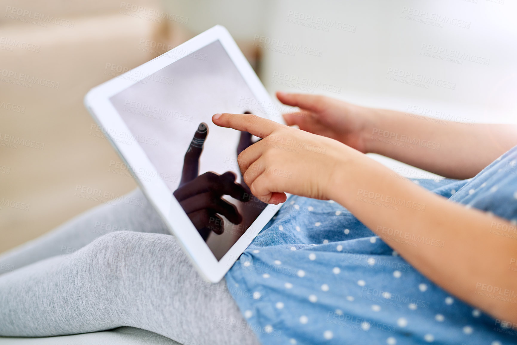 Buy stock photo Closeup shot of a young girl using a digital tablet at home