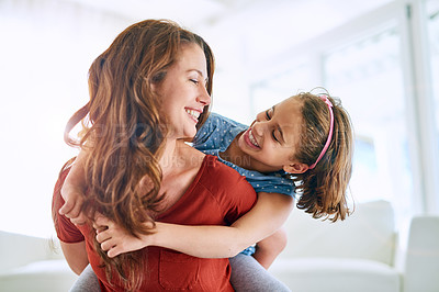 Buy stock photo Cropped shot of a mother giving her daughter a piggyback ride at home