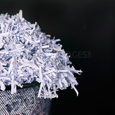 Buy stock photo Studio shot of shredded paper in a dustbin against a black background