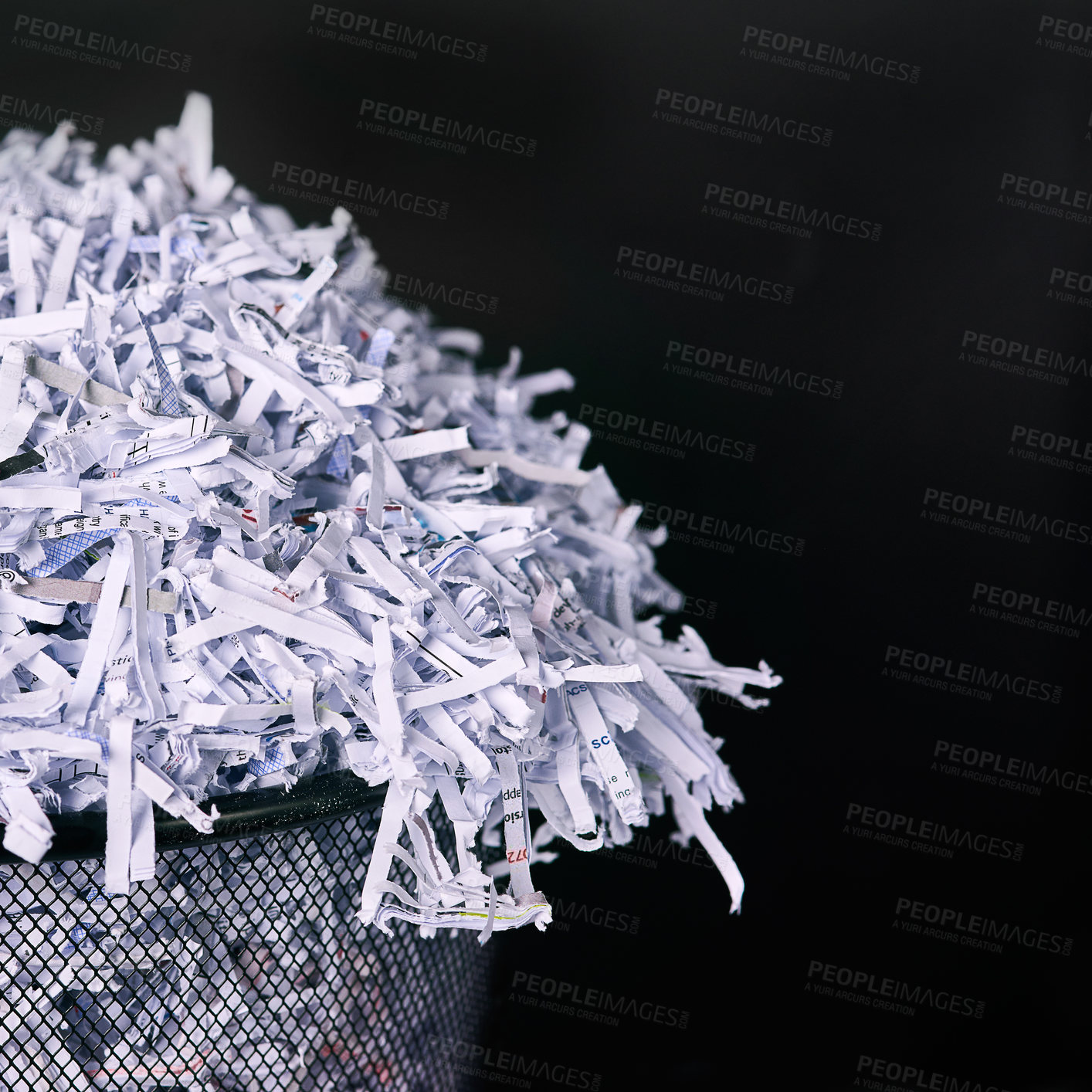 Buy stock photo Studio shot of shredded paper in a dustbin against a black background