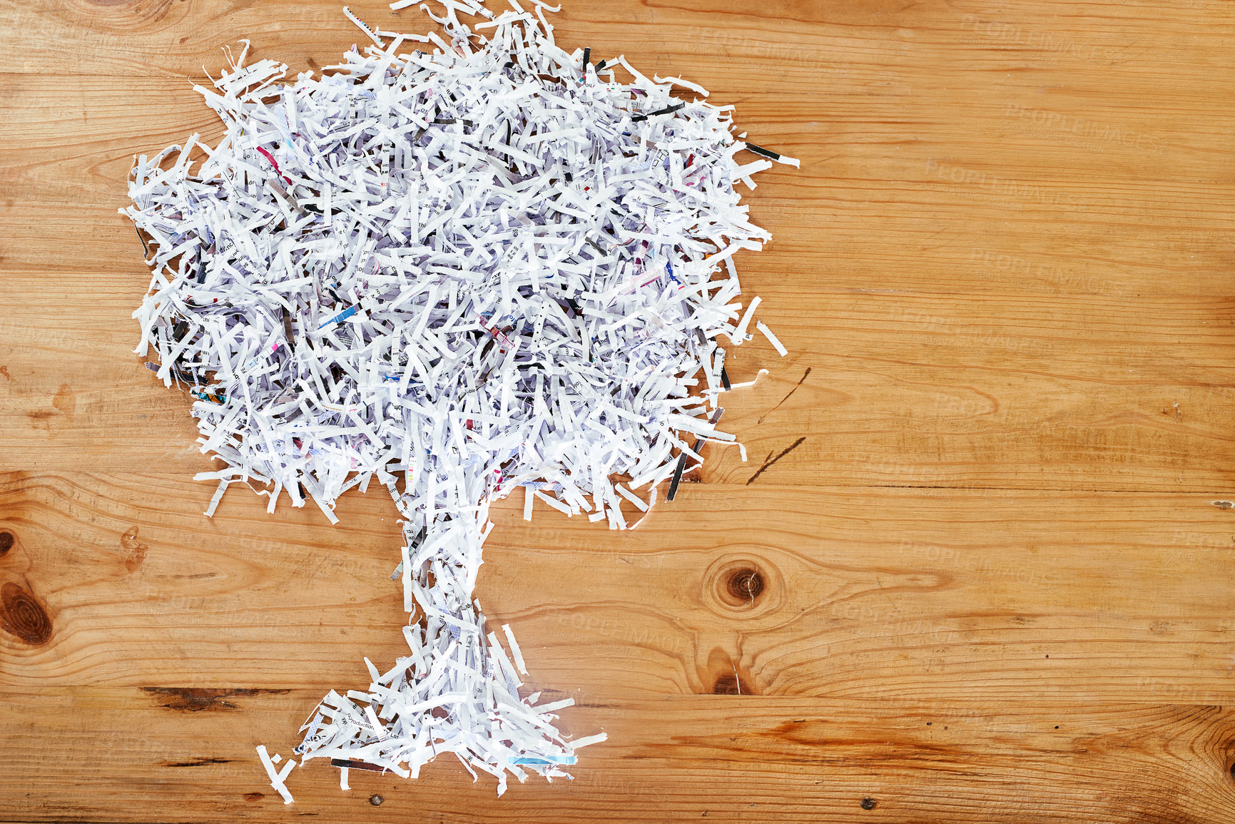 Buy stock photo Studio shot of shredded paper arranged in the shape of a tree on a wooden table
