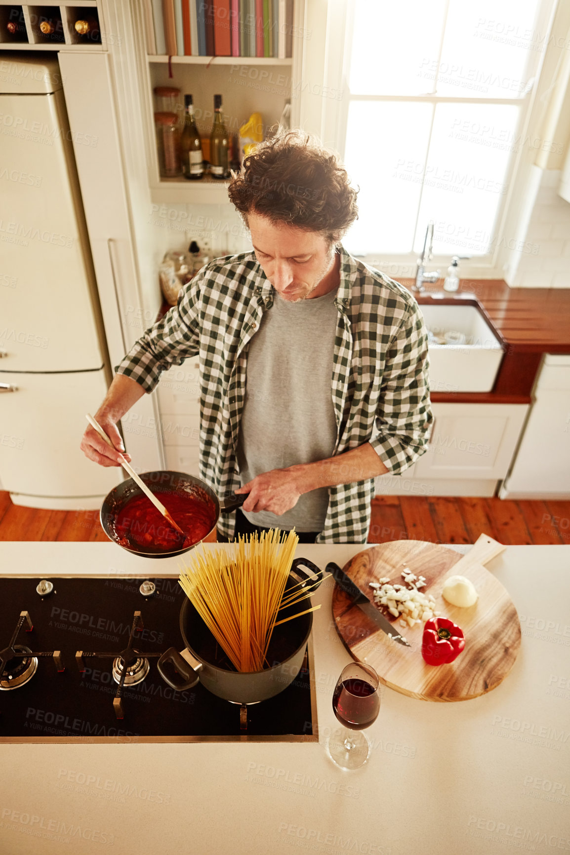 Buy stock photo Spaghetti, cooking or above of man in kitchen with healthy vegan diet for nutrition or vegetables at home in Australia. Wine glass, food or male person in house kitchen in preparation for dinner meal