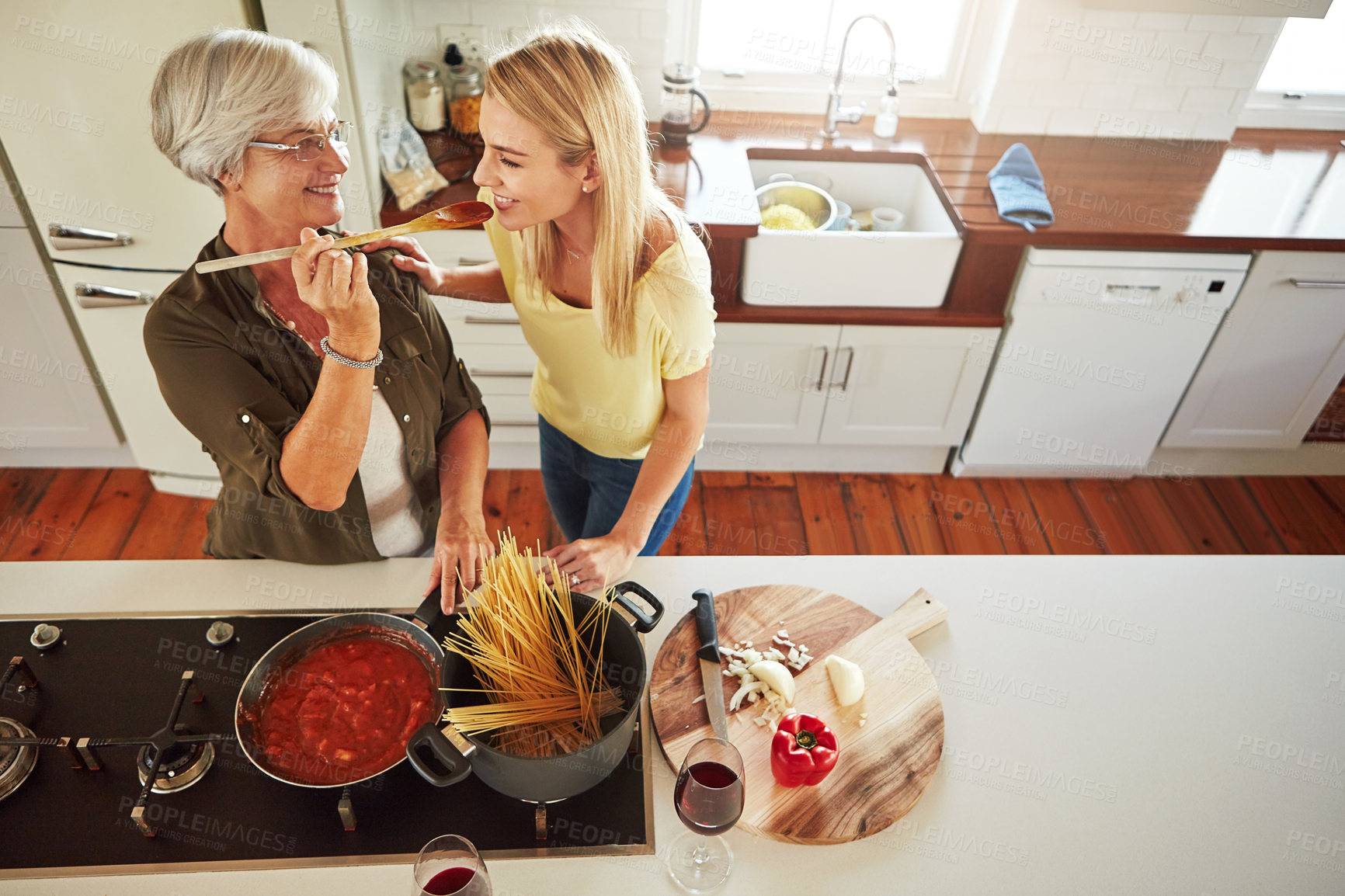 Buy stock photo Taste, woman or mother cooking food for a healthy vegan diet together with love in family home. Smile, tasting or adult child learning or helping senior mom in house kitchen for lunch meal or dinner