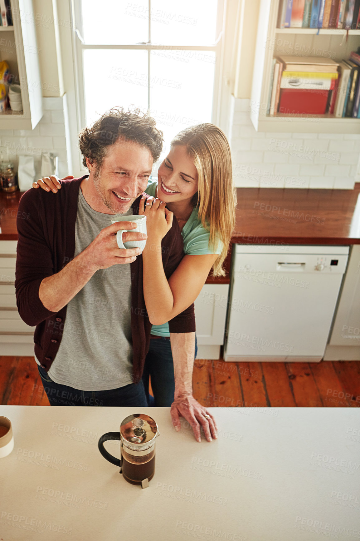 Buy stock photo Hugging, coffee or happy couple laughing in kitchen at home bonding or enjoying quality time together. Embrace, affection or above of funny mature man relaxing or drinking tea with woman at home 