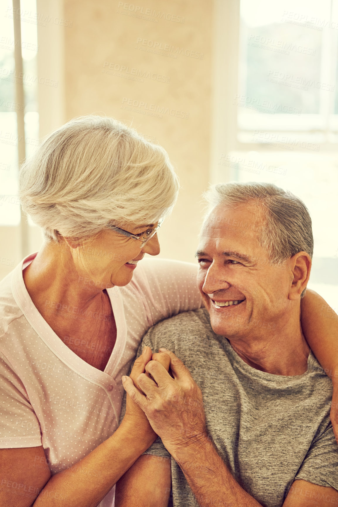 Buy stock photo Cropped shot of a senior couple embracing in their bedroom