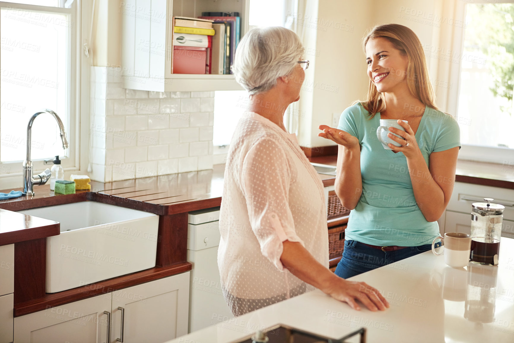 Buy stock photo Mother, coffee or happy woman chatting in kitchen in family home bonding or enjoying quality time together. Smile, retirement or daughter talking, relaxing or drinking tea with senior parent on break