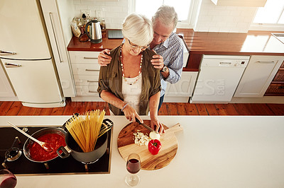 Buy stock photo Affection, support or old couple kitchen cooking with love or healthy food for lunch together at home. Hug, embrace or above of senior woman helping an elderly romantic husband in meal preparation