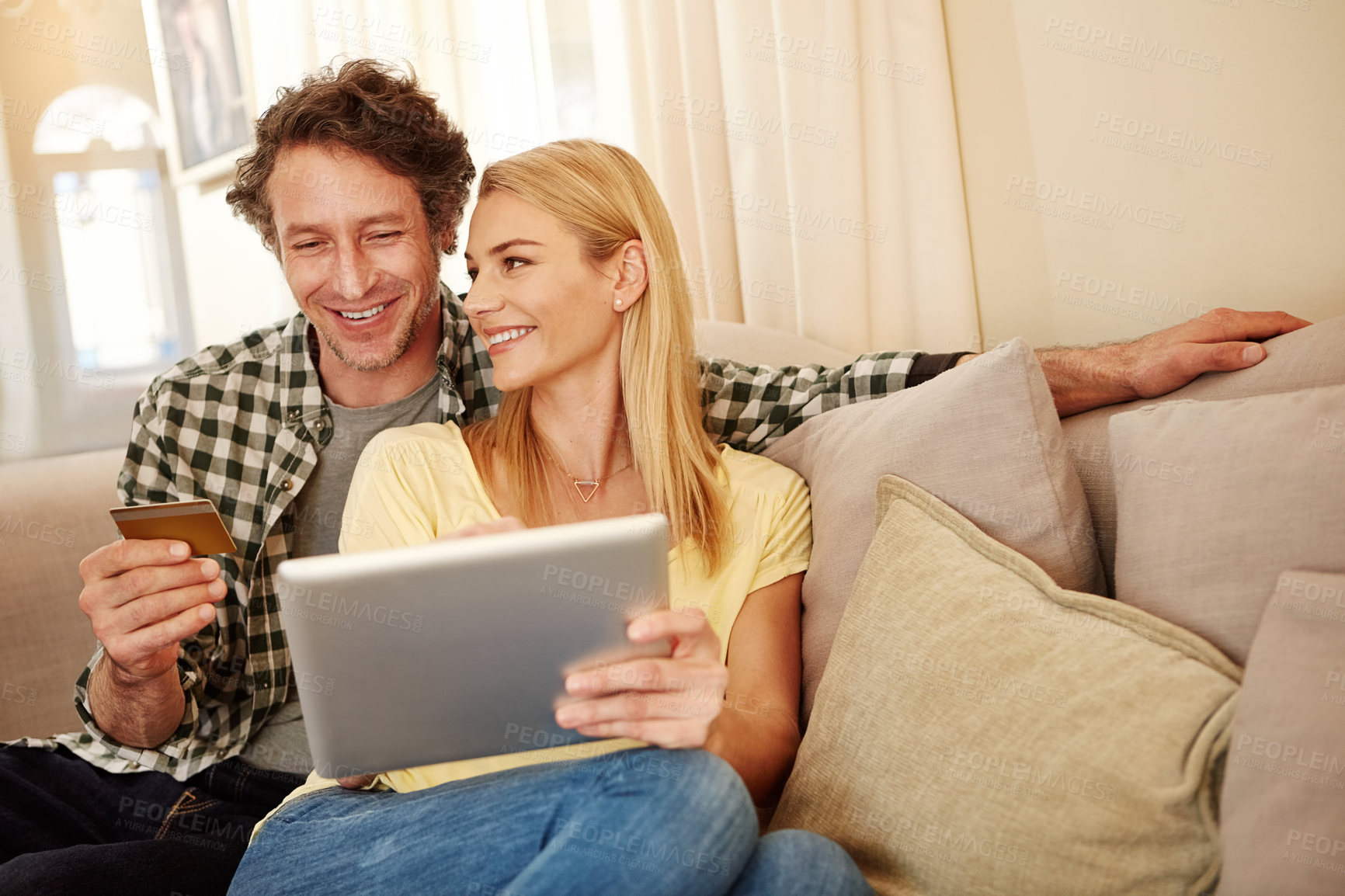 Buy stock photo Cropped shot of a loving couple shopping online on their tablet