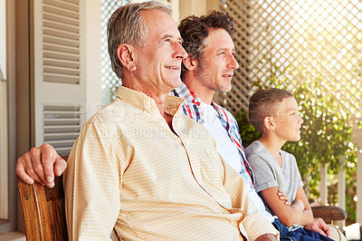 Buy stock photo Cropped shot of a young boy sitting outside with his father and grandfather