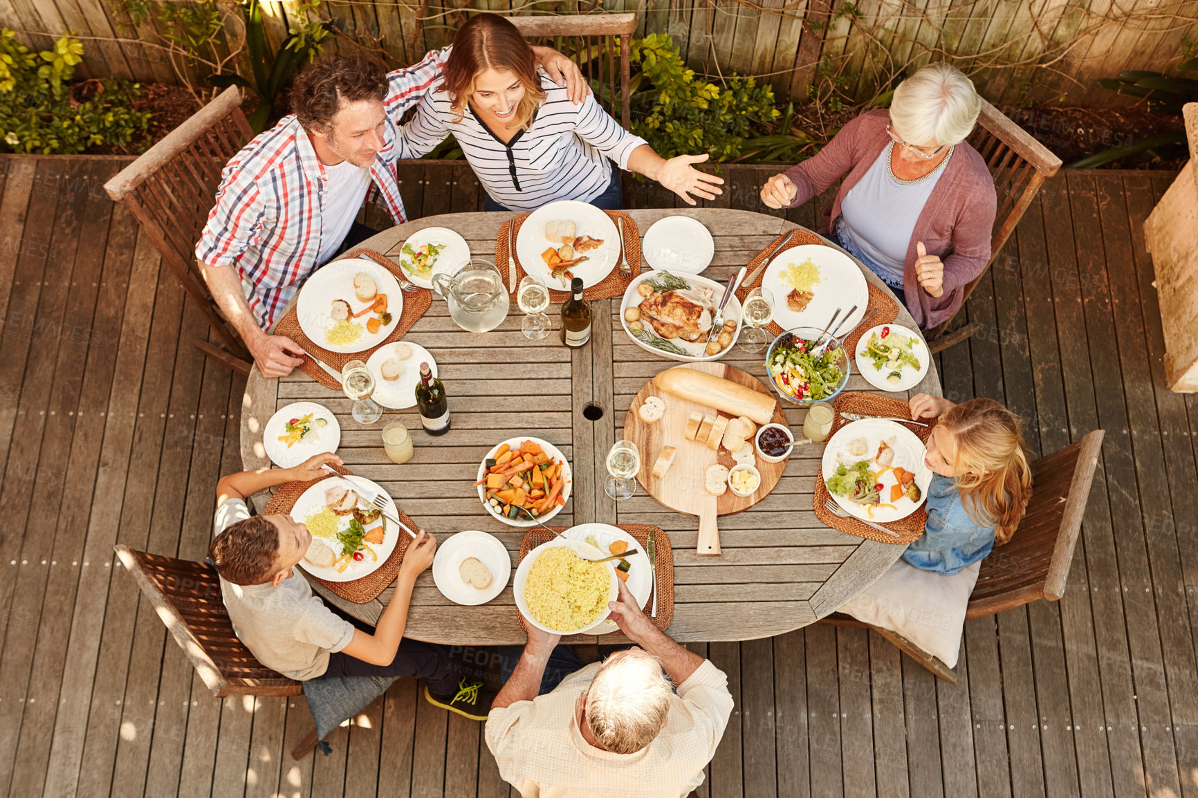 Buy stock photo Table, family and kids at outdoor lunch for bonding, thanksgiving celebration or people eating in backyard. Men, women and children at picnic on patio with food, grandparents and sharing from above