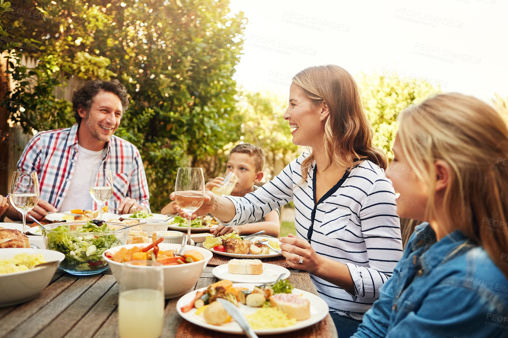 Buy stock photo Shot of a family eating lunch together outdoors