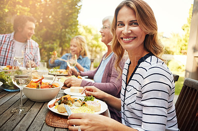 Buy stock photo Portrait of a happy woman enjoying an outdoor lunch with her family
