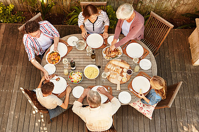 Buy stock photo High angle shot of a family eating lunch outdoors