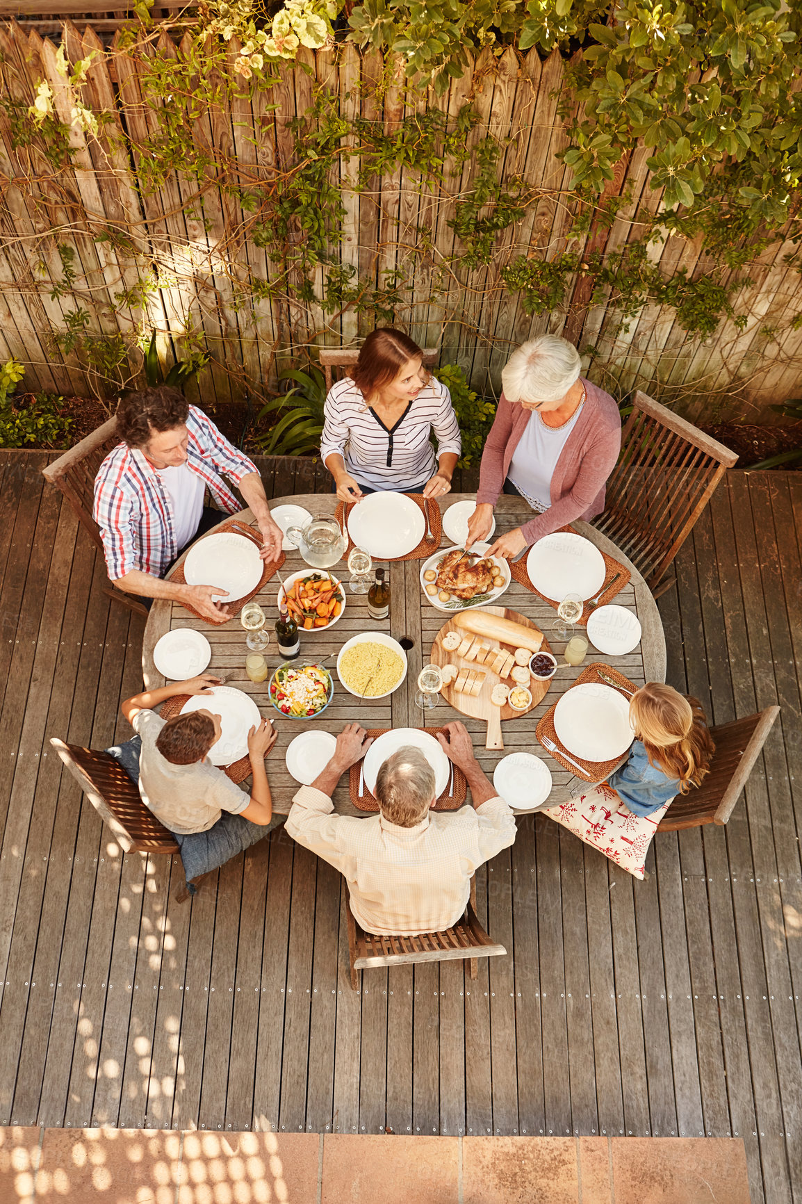 Buy stock photo High angle shot of a family eating lunch outdoors