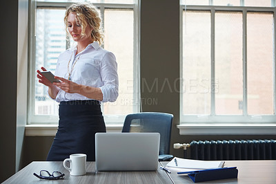 Buy stock photo Shot of a businesswoman using a phone in an office