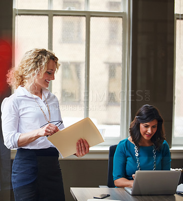 Buy stock photo Shot of a businesswoman going over paperwork in an office