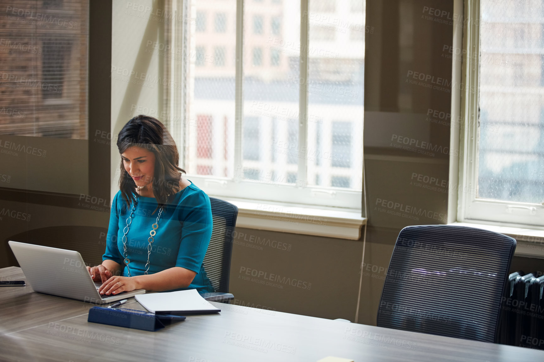 Buy stock photo Shot of a businesswoman using a laptop in an office