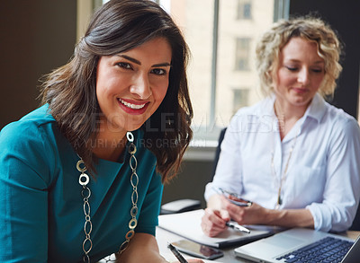 Buy stock photo Portrait of two businesswomen having a meeting together in an office