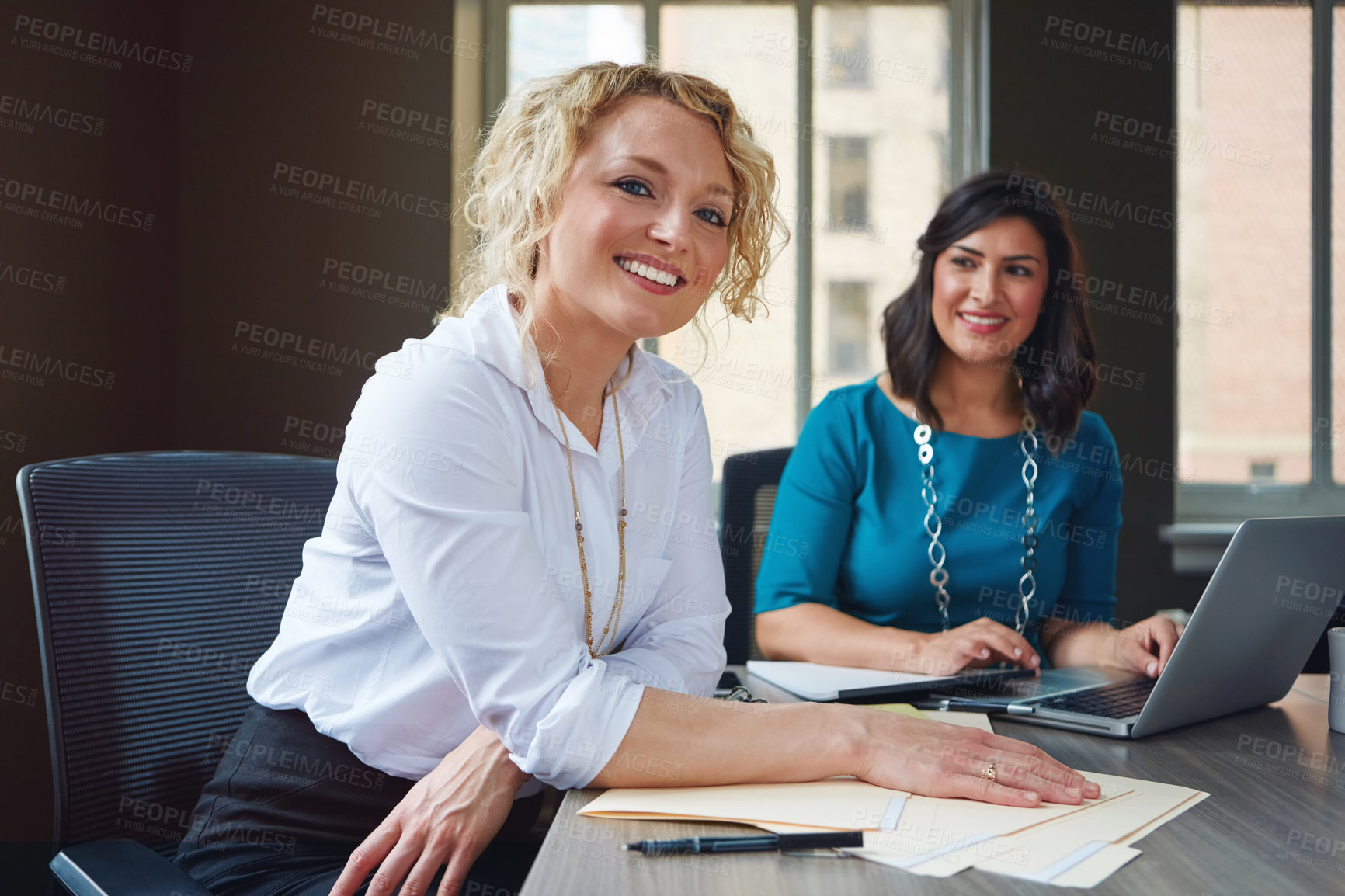 Buy stock photo Portrait of two businesswomen having a meeting together in an office