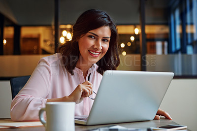 Buy stock photo Portrait of a smiling businesswoman working on a laptop in an office