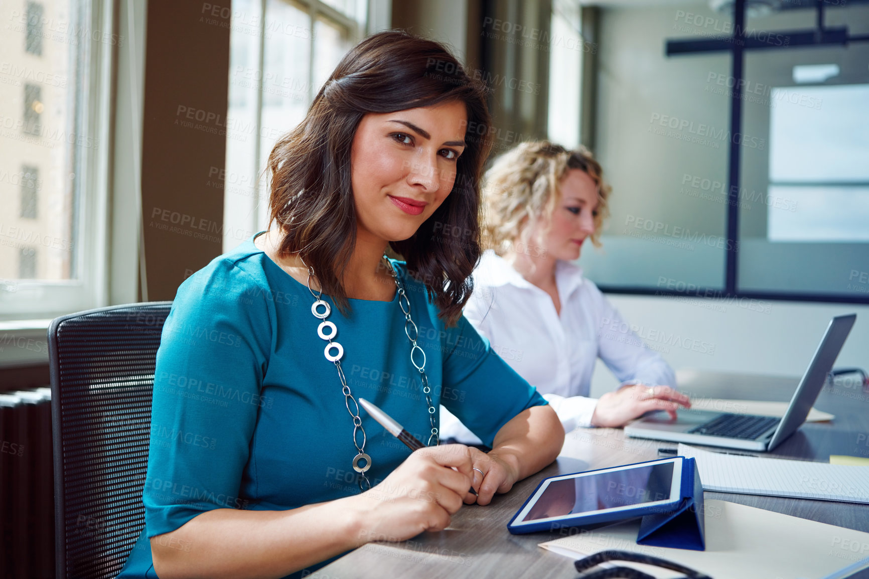 Buy stock photo Portrait of two businesswomen having a meeting together in an office