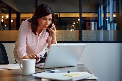 Buy stock photo Shot of a smiling businesswomen talking on a cellphone while standing in an office