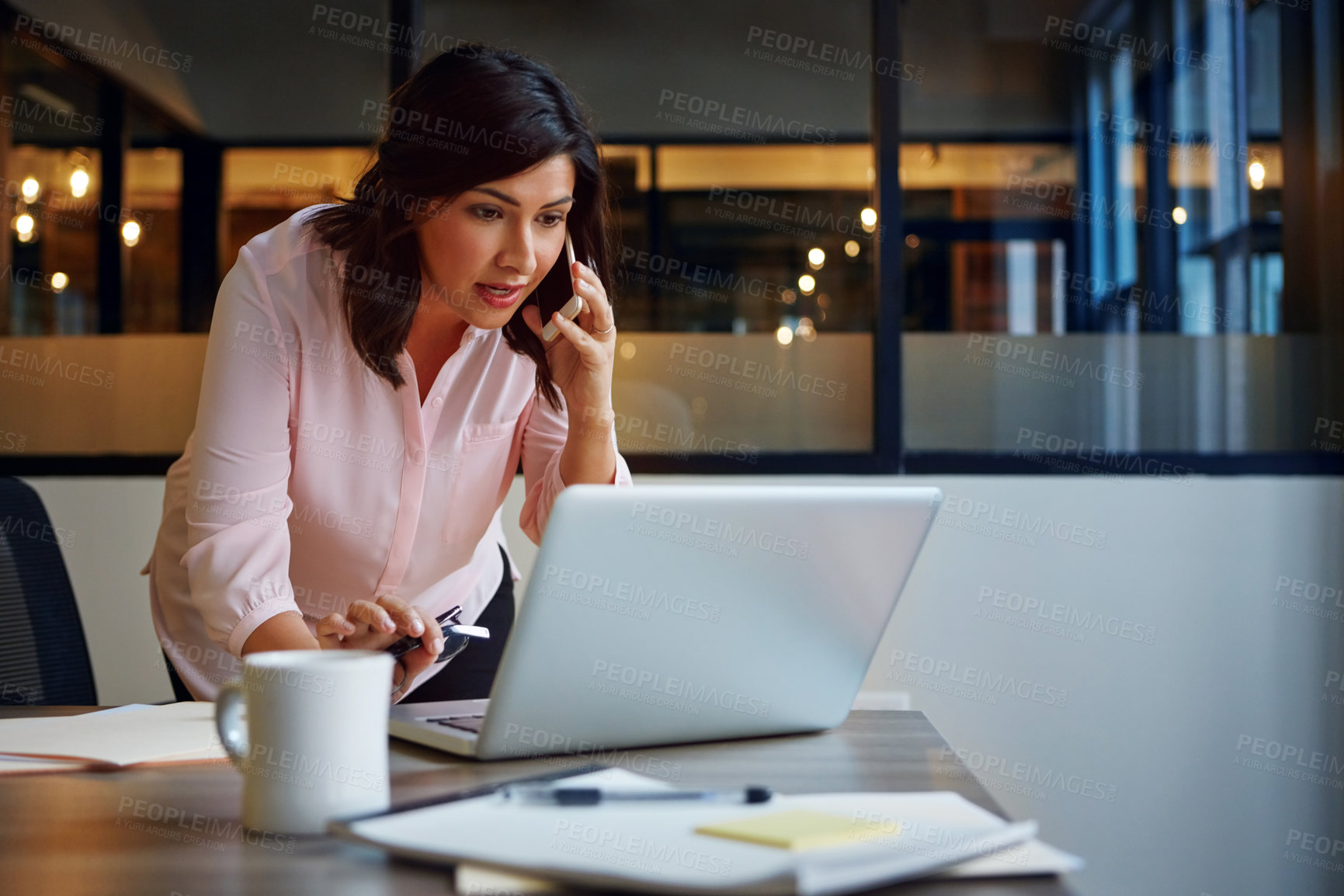 Buy stock photo Shot of a smiling businesswomen talking on a cellphone while standing in an office