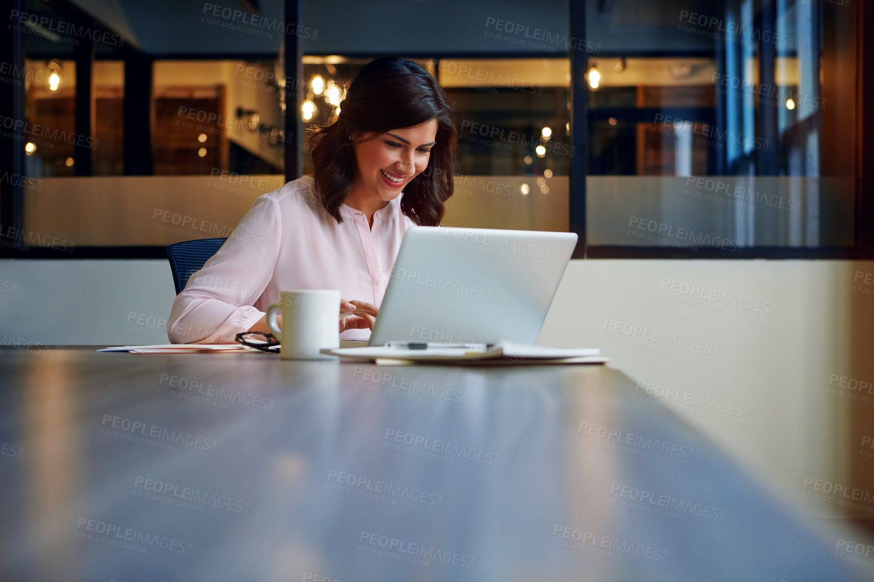 Buy stock photo Shot of a smiling businesswoman working on a laptop in an office