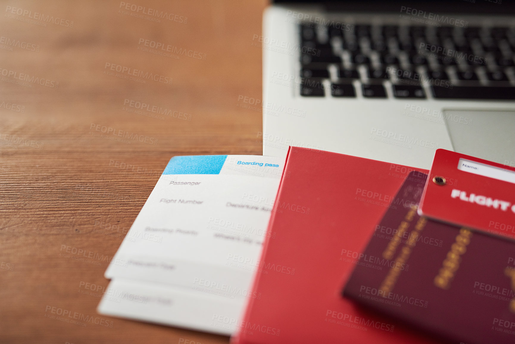 Buy stock photo Shot of travel documents and a laptop on a table