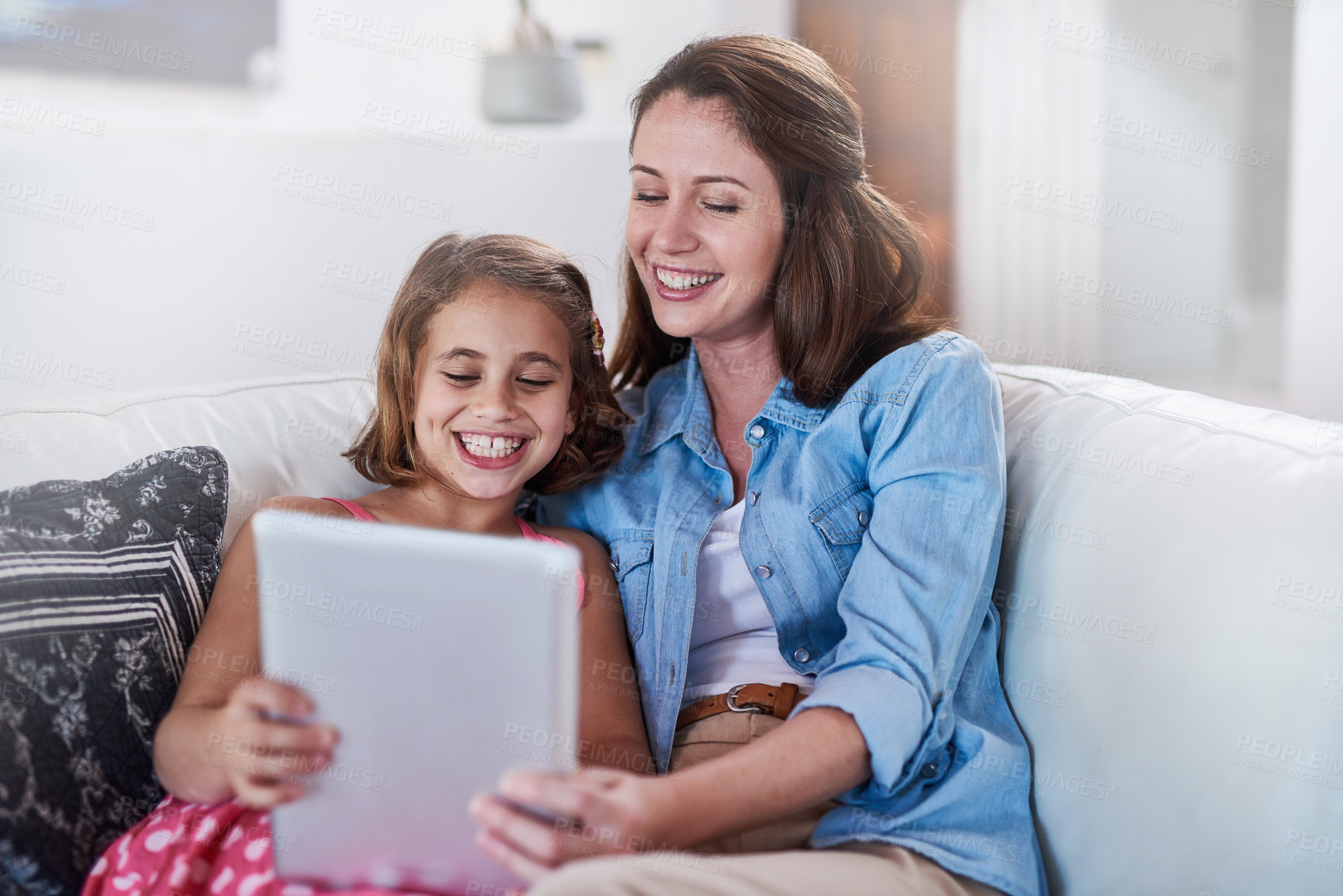 Buy stock photo Cropped shot of a mother and her daughter using wireless technology at home