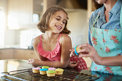 Buy stock photo Mother, child and baking cupcakes or learning together for icing dessert for decoration, sweets or teaching. Woman, daughter and home at kitchen counter for education support as snack, recipe or fun