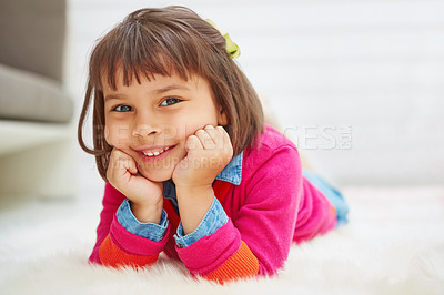 Buy stock photo Portrait of an adorable little girl lying on a rug at home