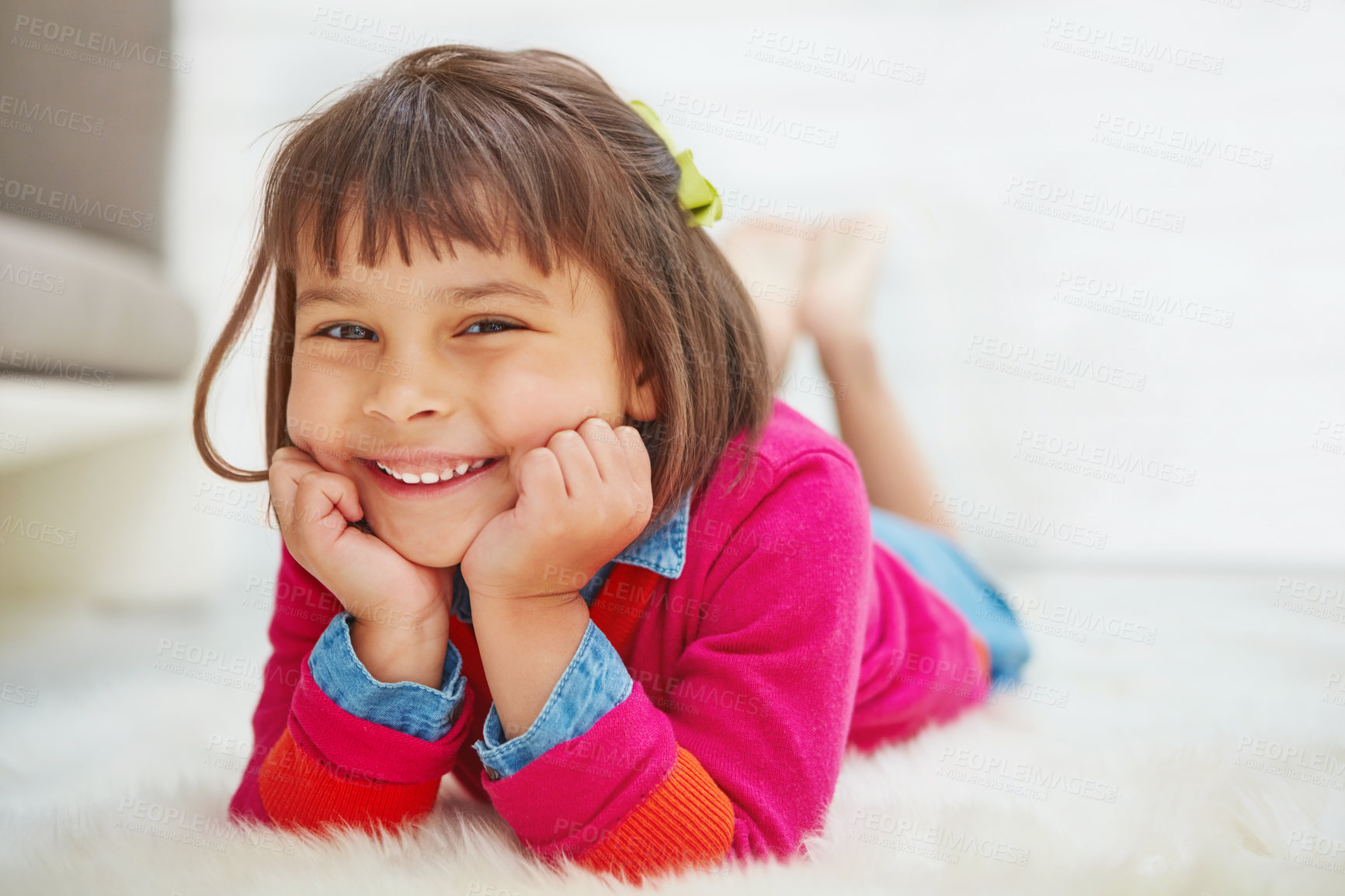 Buy stock photo Portrait of an adorable little girl lying on a rug at home