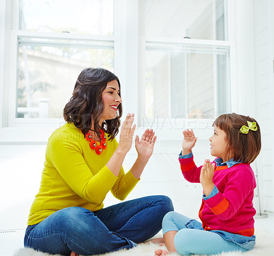 Buy stock photo Shot of an adorable little girl playing a clapping game with her mother at home