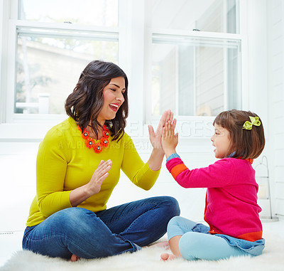 Buy stock photo Shot of an adorable little girl playing a clapping game with her mother at home