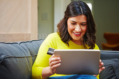Buy stock photo Shot of a woman using her tablet and credit card at home