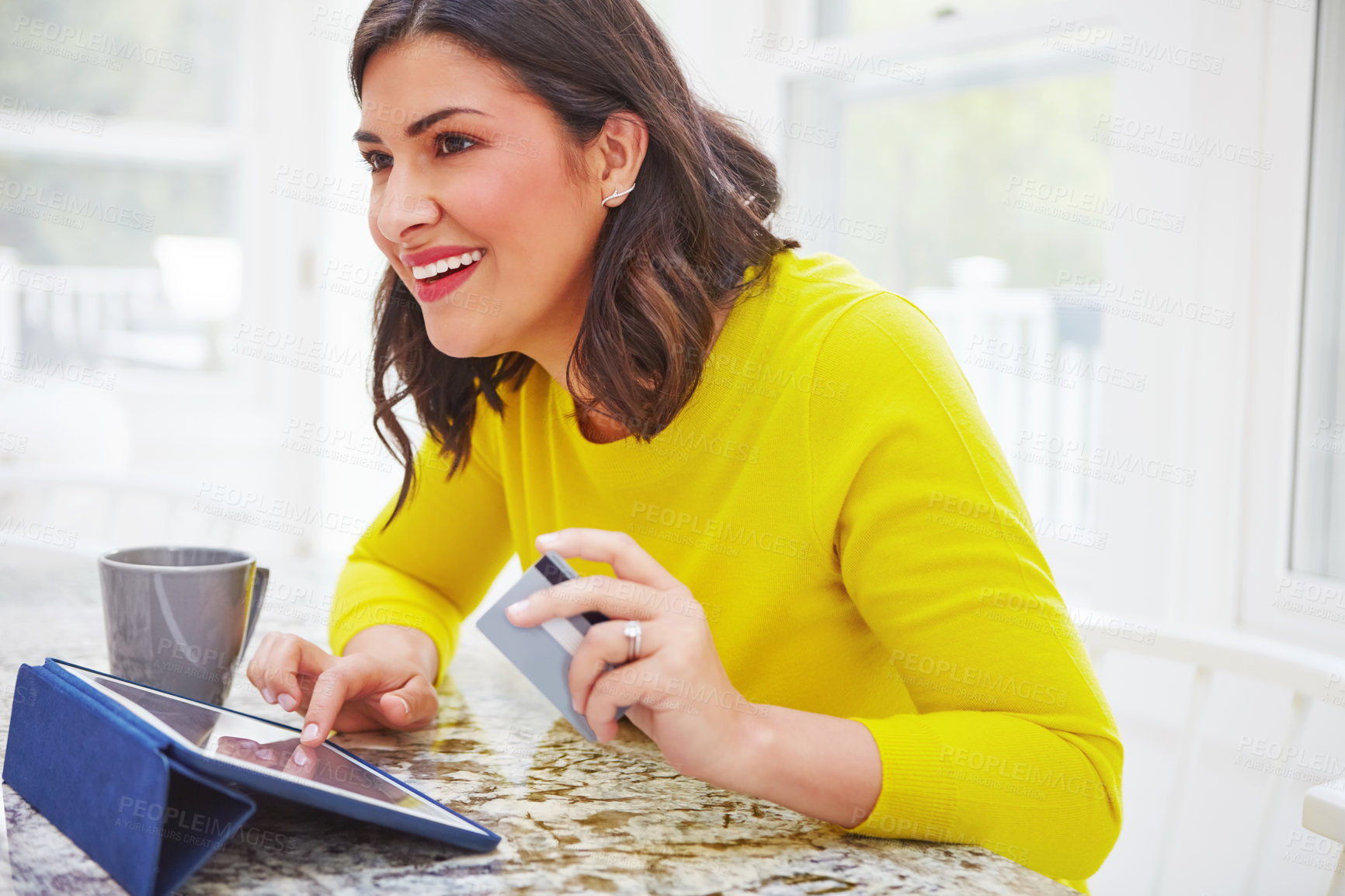 Buy stock photo Shot of a woman using her tablet and credit card at home