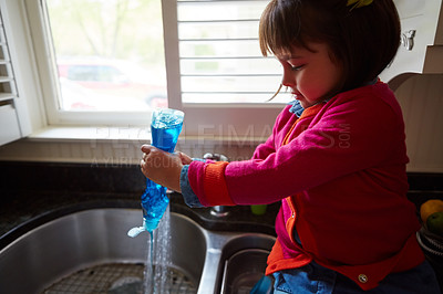 Buy stock photo Shot of a little girl pouring soap into a kitchen sink
