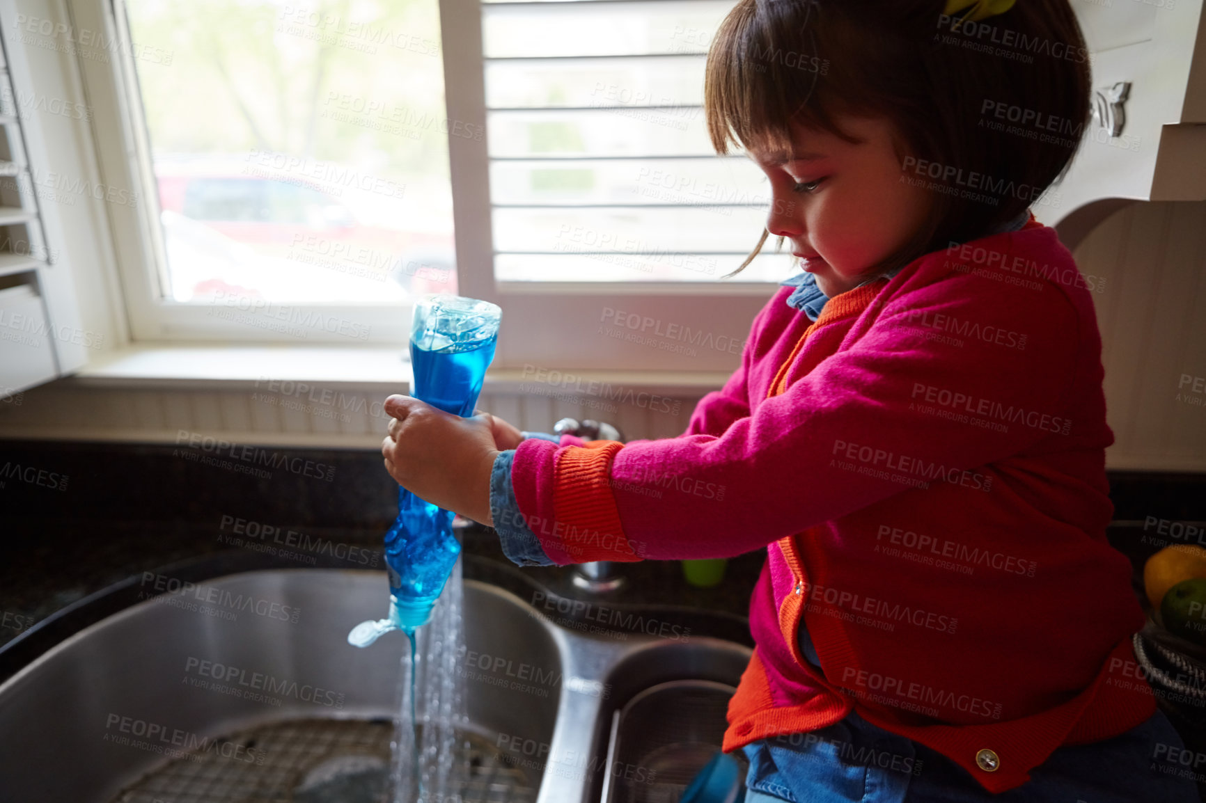 Buy stock photo Shot of a little girl pouring soap into a kitchen sink