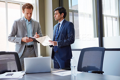 Buy stock photo Cropped shot of businessmen looking at paperwork in their office