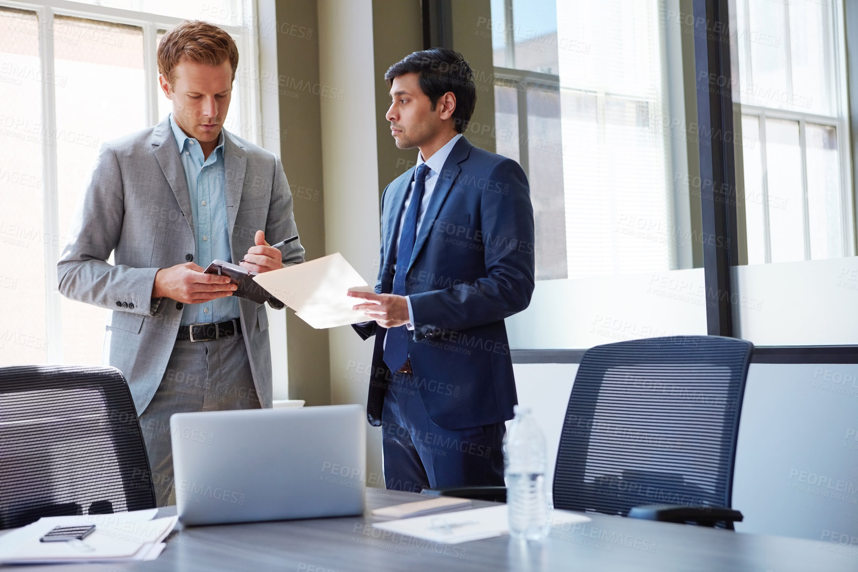 Buy stock photo Cropped shot of businessmen looking at paperwork in their office