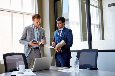 Buy stock photo Cropped shot of businessmen looking at paperwork in their office