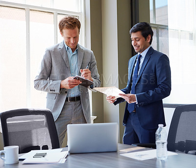 Buy stock photo Cropped shot of businessmen looking at paperwork in their office