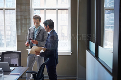 Buy stock photo Cropped shot of businessmen looking at paperwork in their office