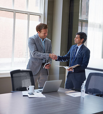 Buy stock photo Cropped shot of two businessmen shaking hands in the office