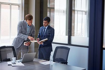 Buy stock photo Cropped shot of businessmen looking at paperwork in their office