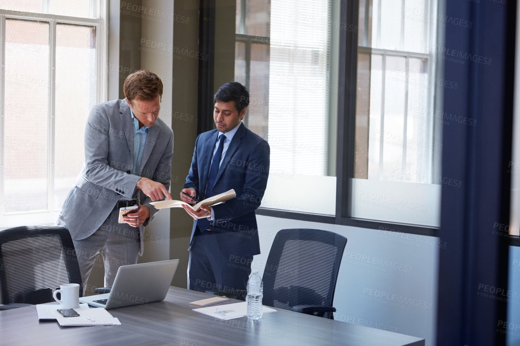 Buy stock photo Cropped shot of businessmen looking at paperwork in their office