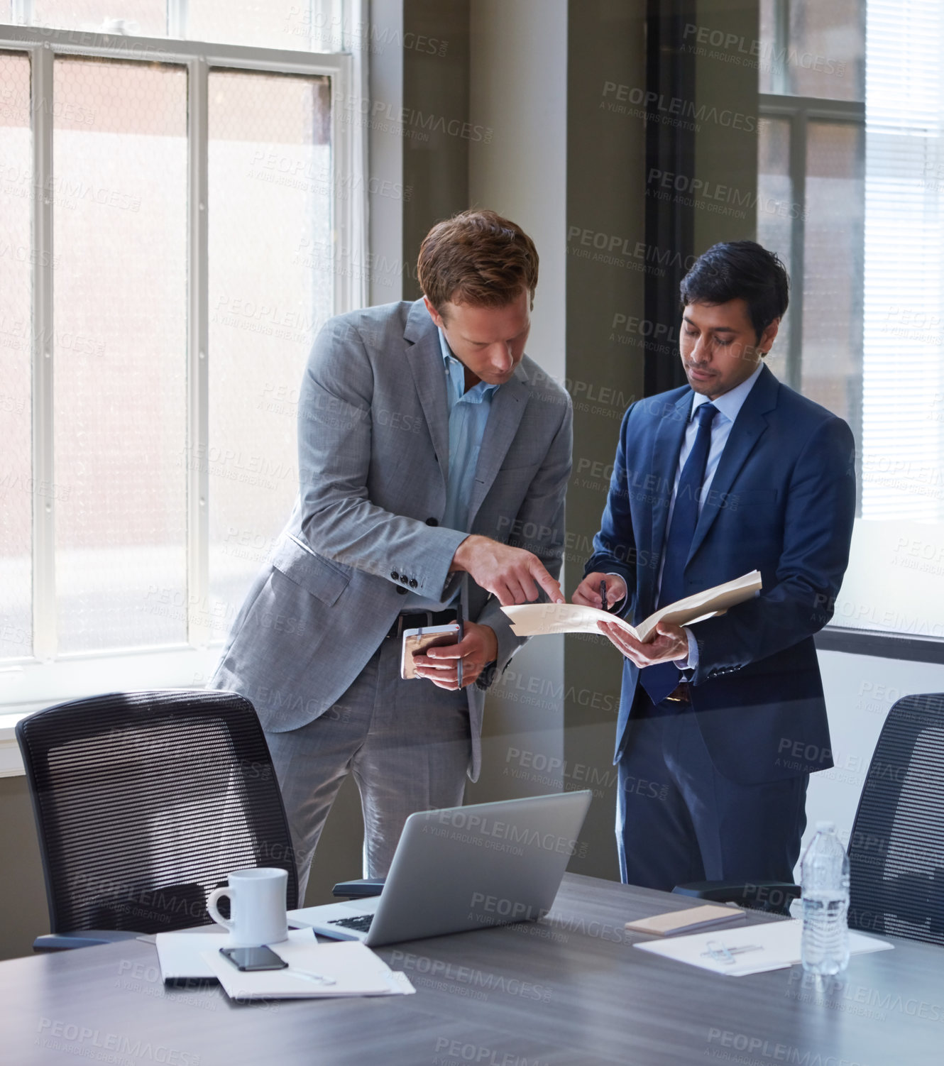 Buy stock photo Cropped shot of businessmen looking at paperwork in their office