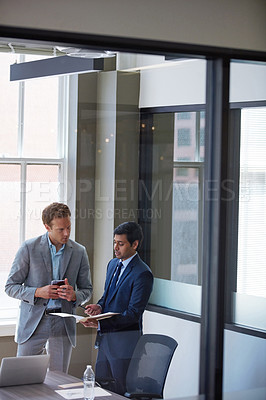 Buy stock photo Cropped shot of businessmen looking at paperwork in their office